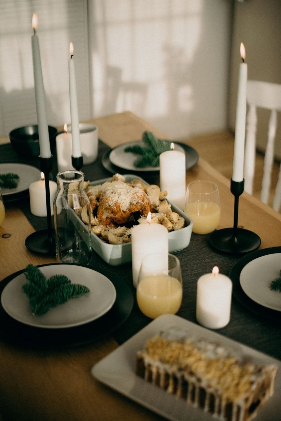 Mesa de Natal com velas altas e pratos com guardanapos