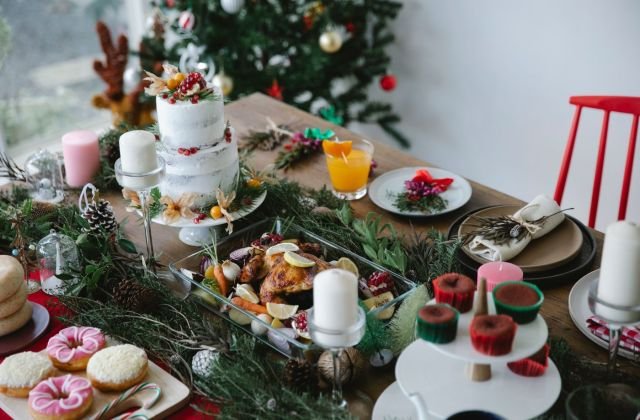 Mesa de Natal com bolo, doces, salgados e ramos de pinheiro