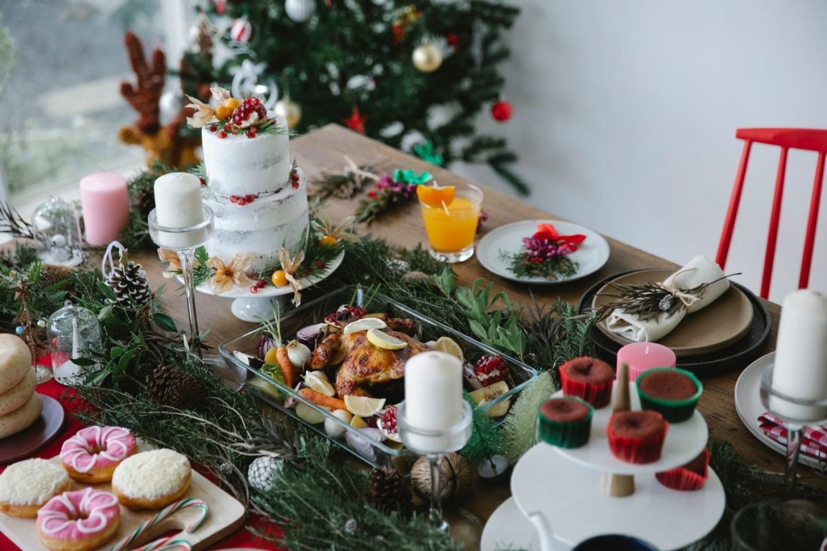 Mesa de Natal com bolo, doces, salgados e ramos de pinheiro