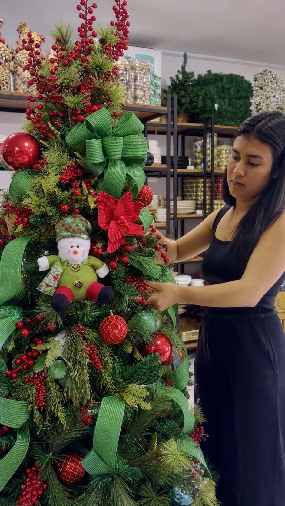 Beatriz Milli ao lado da árvore finalizada na loja Arte na Mesa