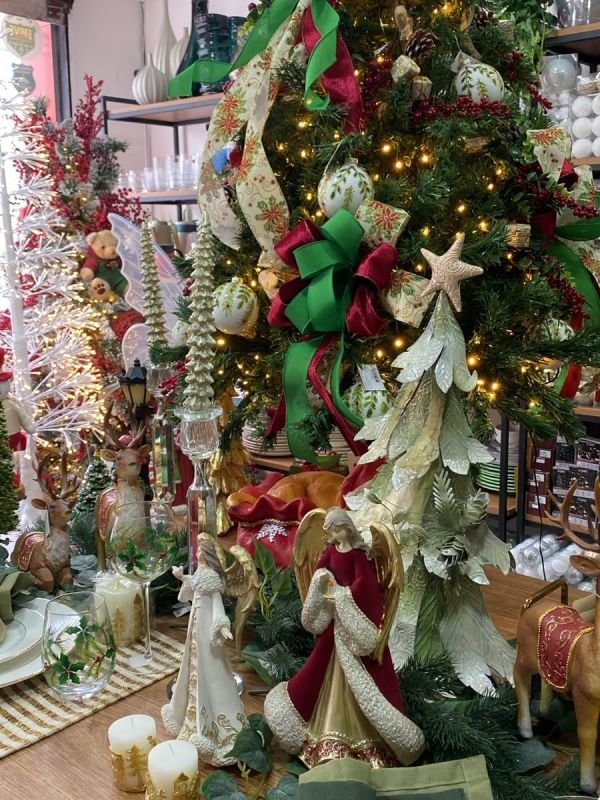Árvore de Natal com laços vermelhos, verdes e dourados e anjos decorativos