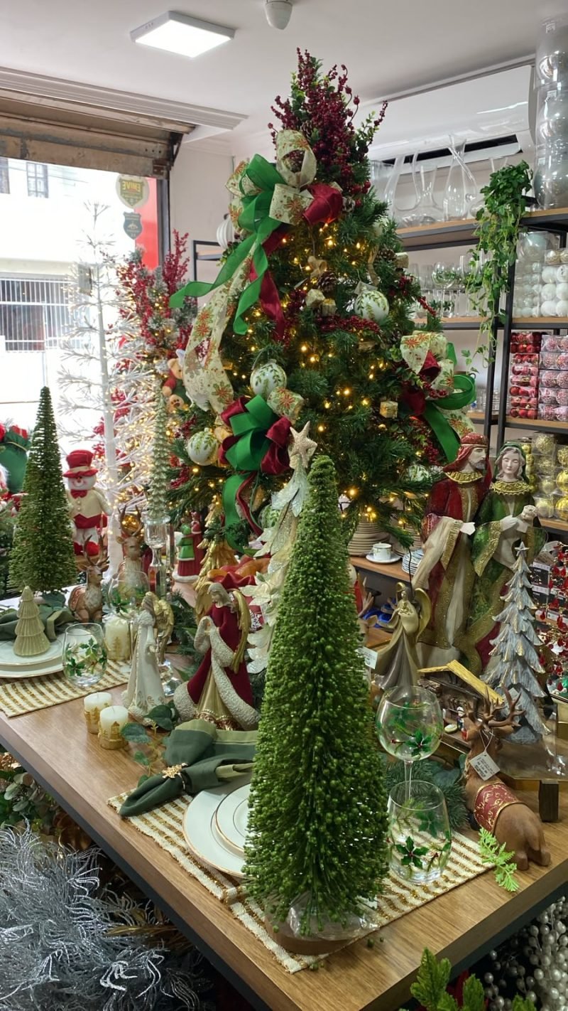 Árvore de Natal com laços vermelhos e verdes e mesa posta decorada, decoração de Natal para lojas e empresas