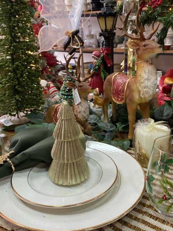 Mesa posta de Natal com renas, árvore de vela dourada e guardanapo verde